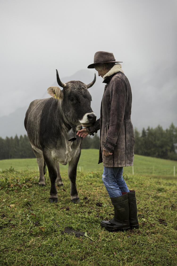 Bäuerin mit Kuh auf einer Weide